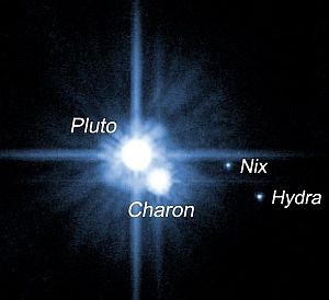 The dwarf planet Pluto, showing three of its five moons